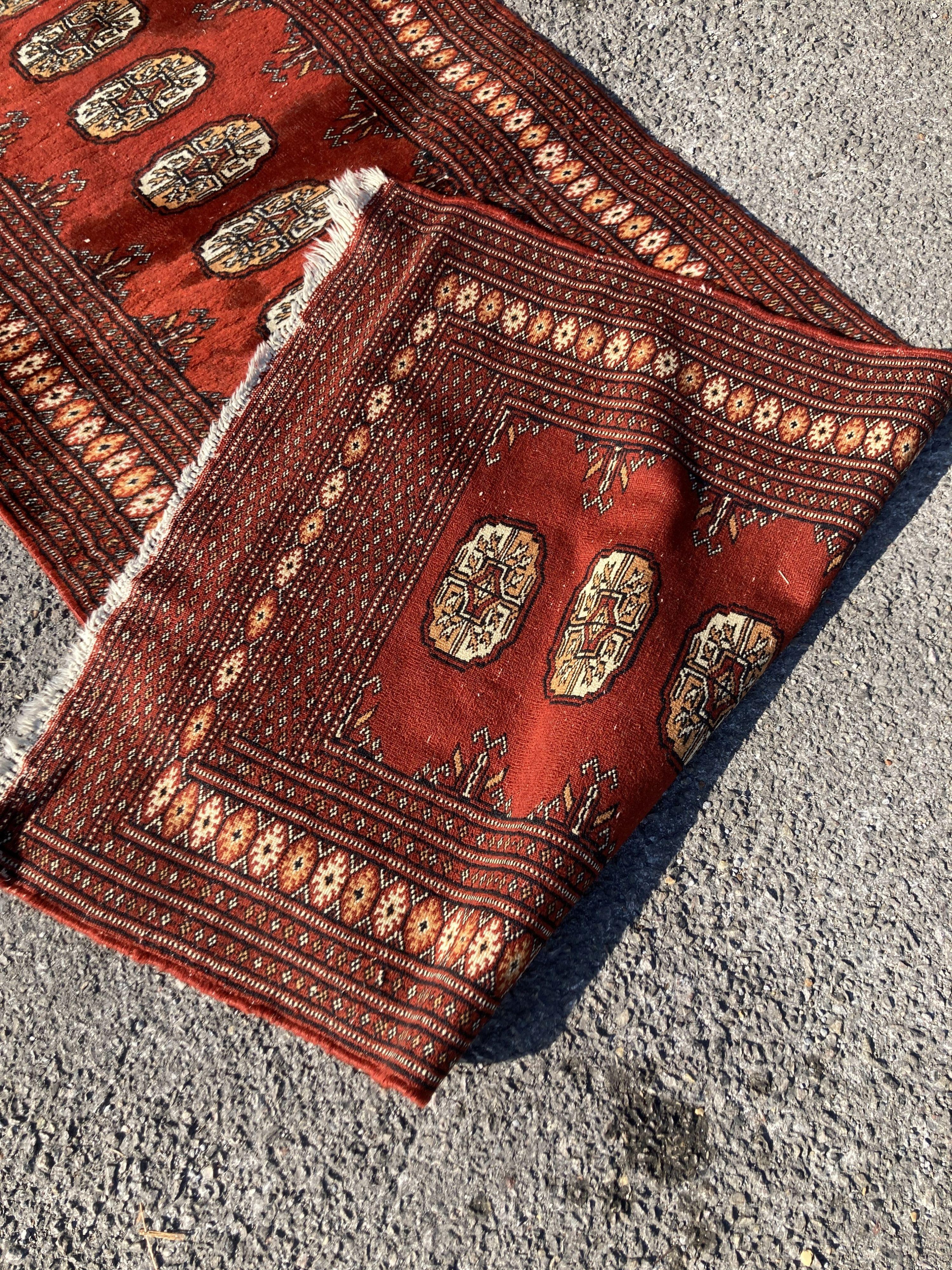 A Bokhara red ground runner with multi medallion field, 326 x 80cm